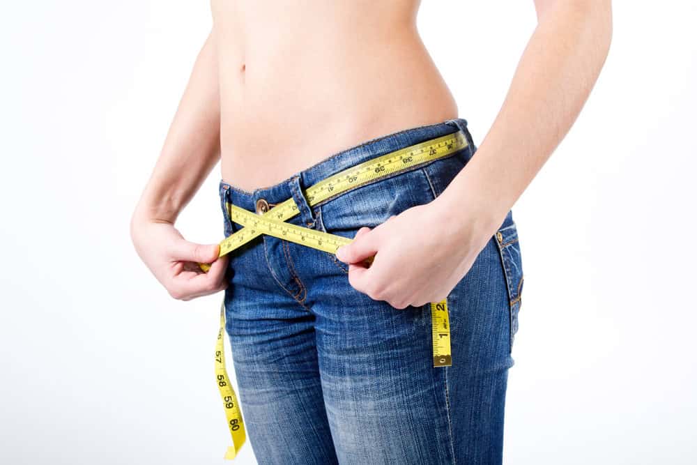 Intermittent Fasting: What Is It, Benefits & How Does It Work? - cropped image woman measuring her waist 1